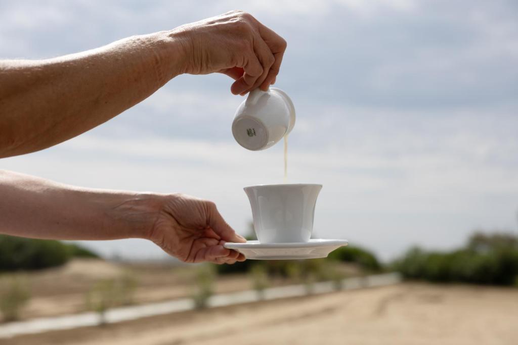 a person holding a cup in their hands at Hotel Continental in Caorle