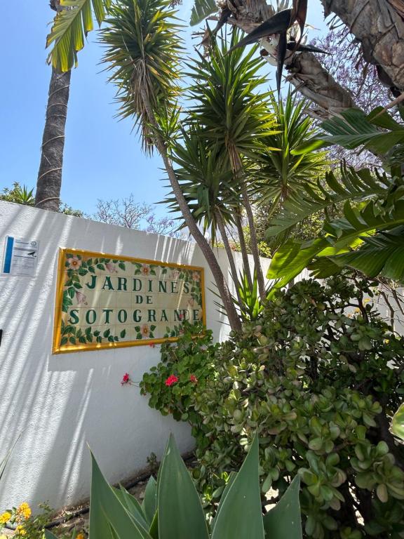 Un cartel de entrada a un complejo turístico con palmeras. en Sotogrande apartamento duplex, en Sotogrande