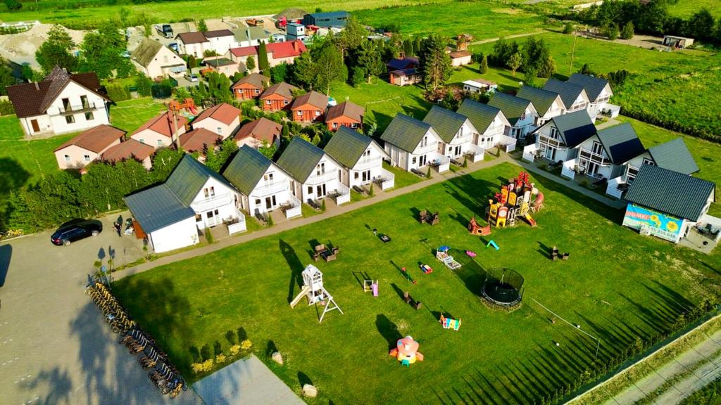 an aerial view of a village with people on a lawn at Słonecznikowa Dolina in Sarbinowo