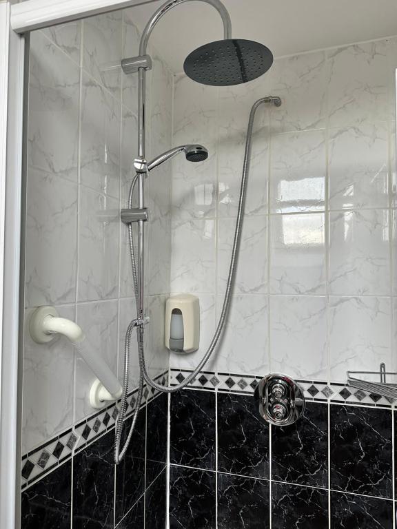 uma casa de banho com uma cabeça de chuveiro em Malahide Guest Rooms em Malahide