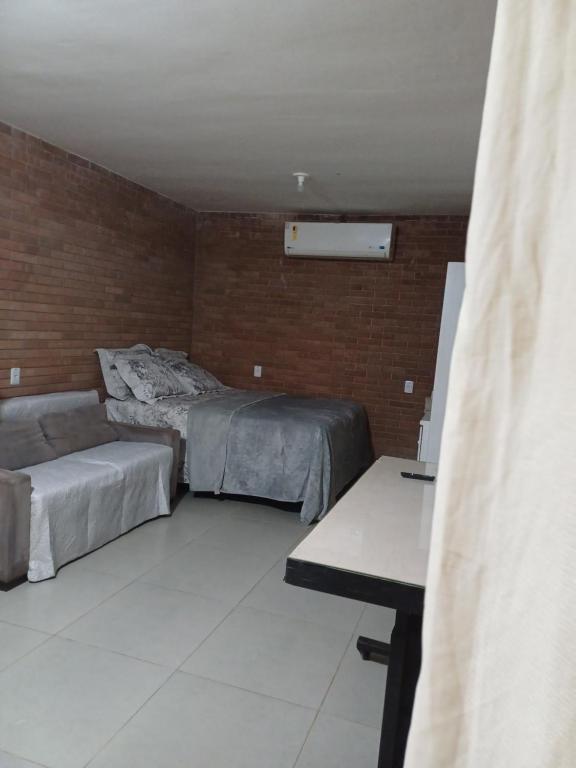 Cette chambre comprend 2 lits et une table. dans l'établissement Casa aconchegante, à Bragança Paulista