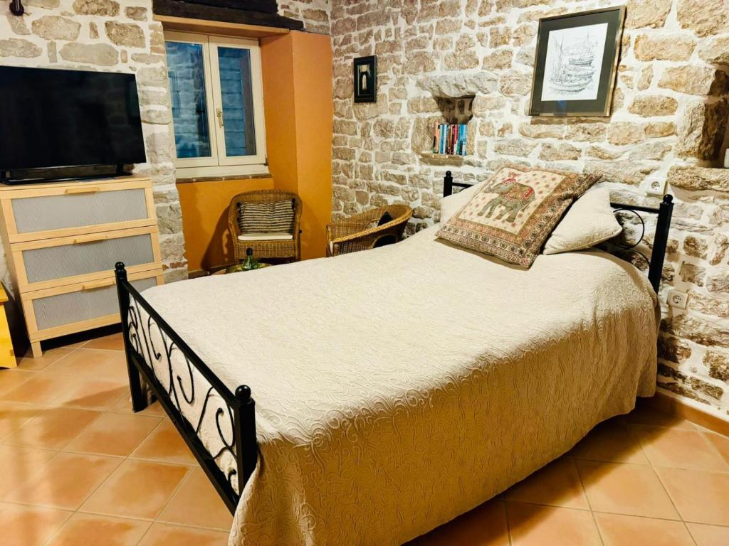 a bedroom with a large bed in a room with stone walls at Romantic studio old town in Vrsar