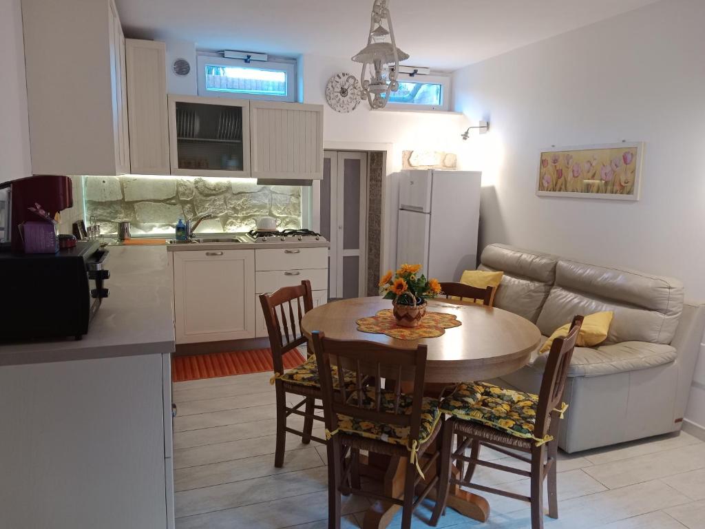 una cucina e un soggiorno con tavolo e sedie di Appartamento bilocale ERICA a Monteriggioni