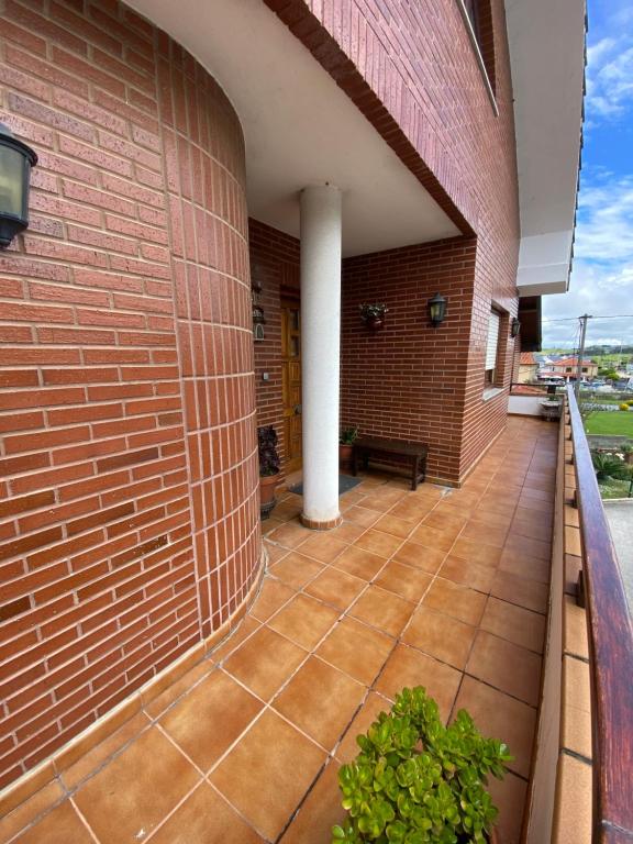 a patio with a brick wall and a white pillar at Apartamento Las Torcas en Mogro in Mogro