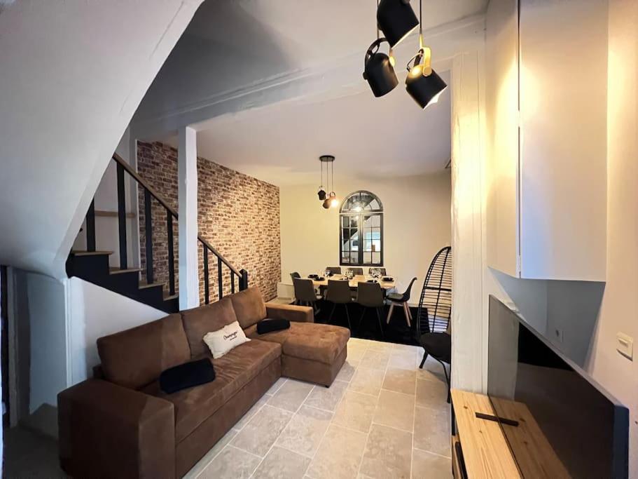 un salon avec un canapé et une salle à manger dans l'établissement Gîtes atypique champenois, à Saint-Martin-dʼAblois