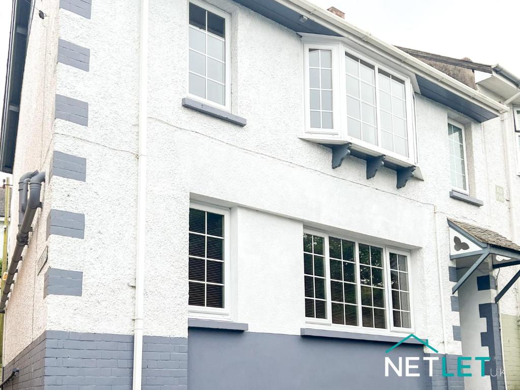 ein weißes Gebäude mit Seitenfenstern in der Unterkunft Hill House in Pembrokeshire