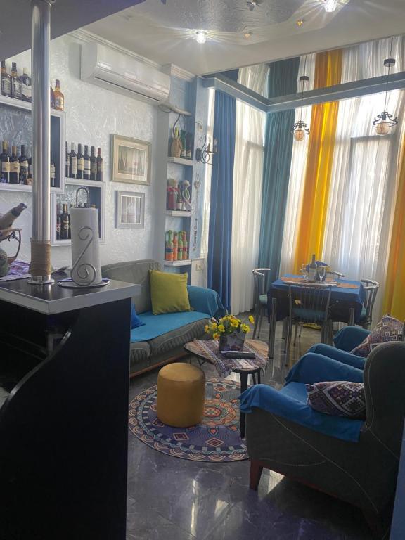 ein Wohnzimmer mit blauen Sofas und einem Tisch in der Unterkunft Dea Apartments in Batumi