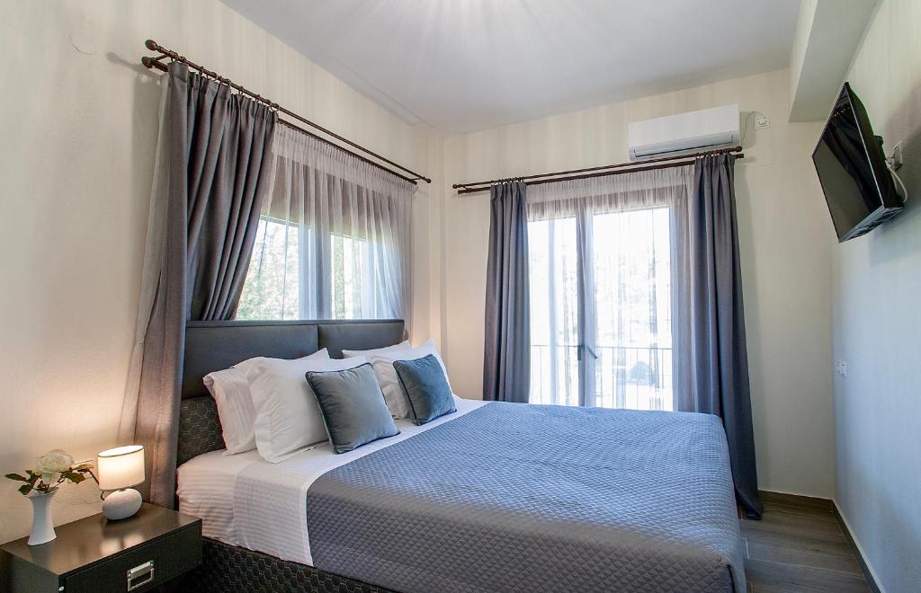1 dormitorio con cama y ventana grande en Ben’s Apartments, en Agia Paraskevi