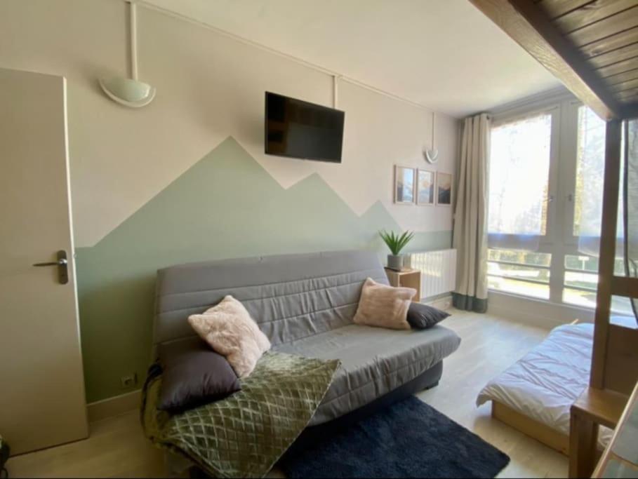 un salon avec un canapé et une télévision dans l'établissement Appartement Au plaisir - Front de neige, Antarès, à Villarembert