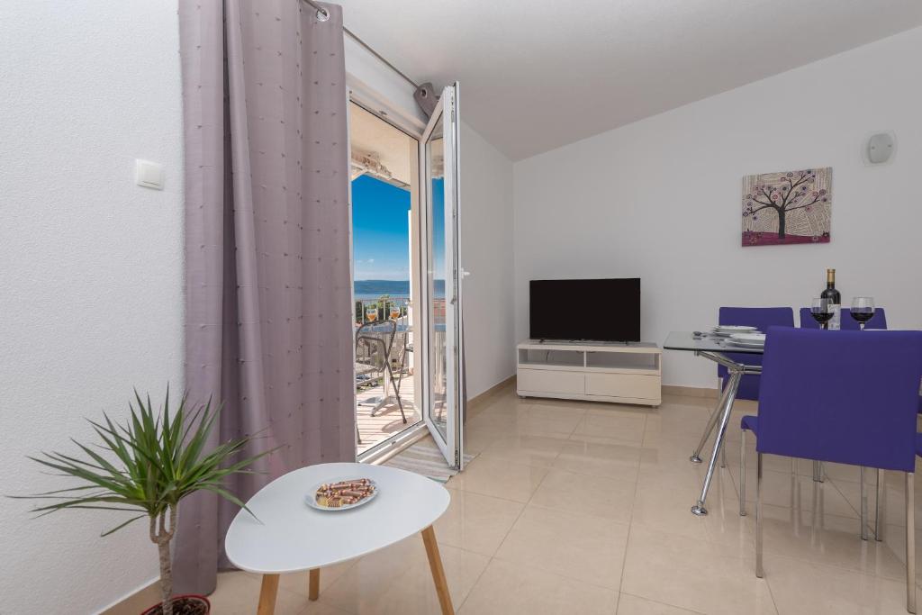 a living room with a table and a tv at Apartments Nina M in Baška Voda