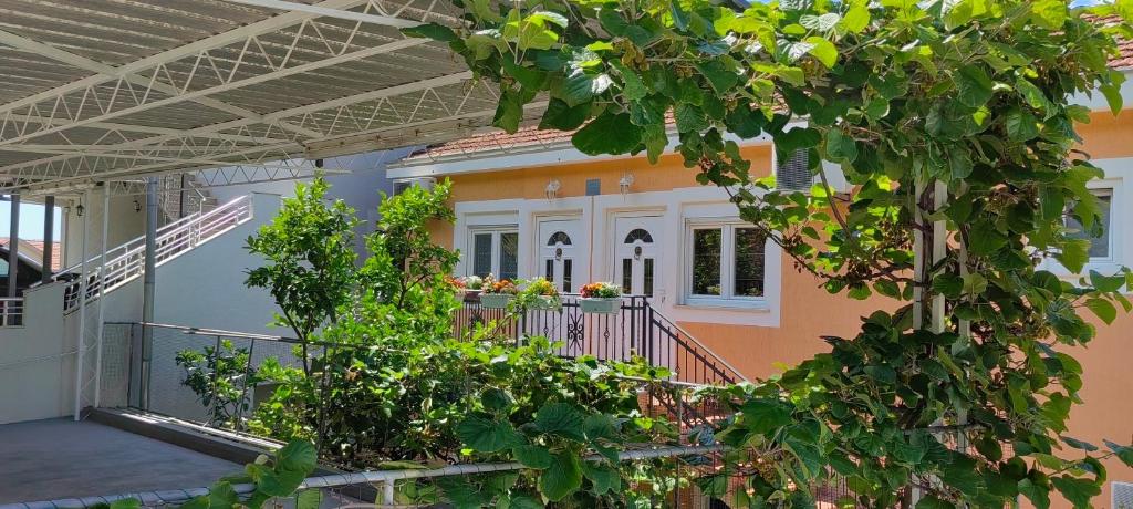 une maison orange avec un balcon et des plantes dans l'établissement Apartmani Milicevic, à Igalo