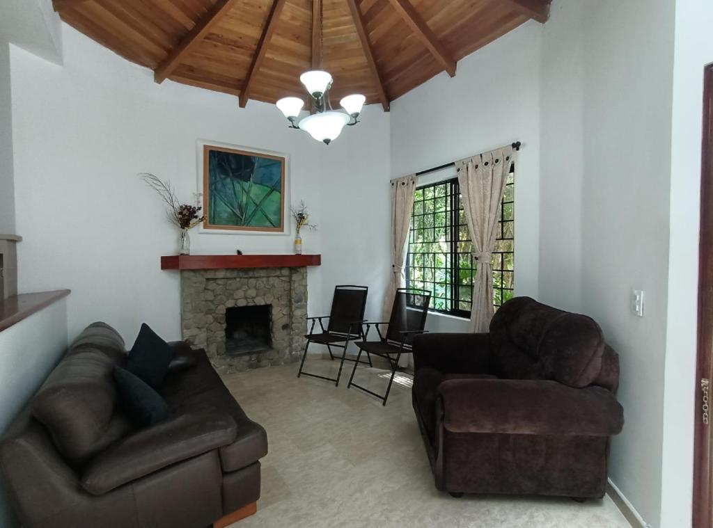 ein Wohnzimmer mit 2 Sofas und einem Kamin in der Unterkunft Casa Campestre Poblado para 8 in Medellín