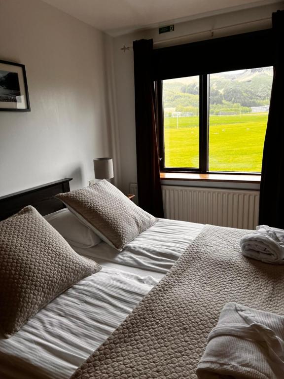 a bedroom with two beds and a window at Hotel Skógá by EJ Hotels in Skogar