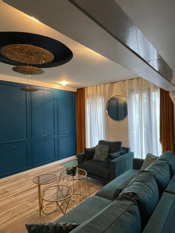 un salon avec un canapé bleu et des tables dans l'établissement Superbe loft au coeur de Paris, à Paris