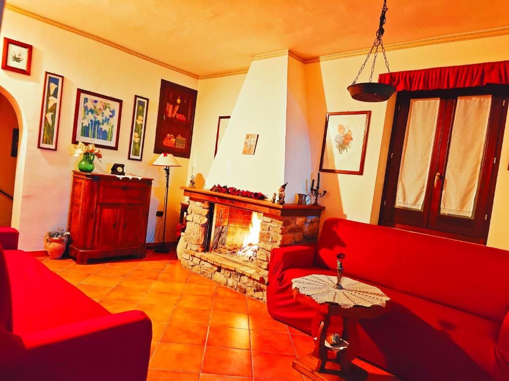 a living room with red couches and a fireplace at Relax Destinazioni Viaggio-Struttura Abruzzo/Molise in Forlì del Sannio