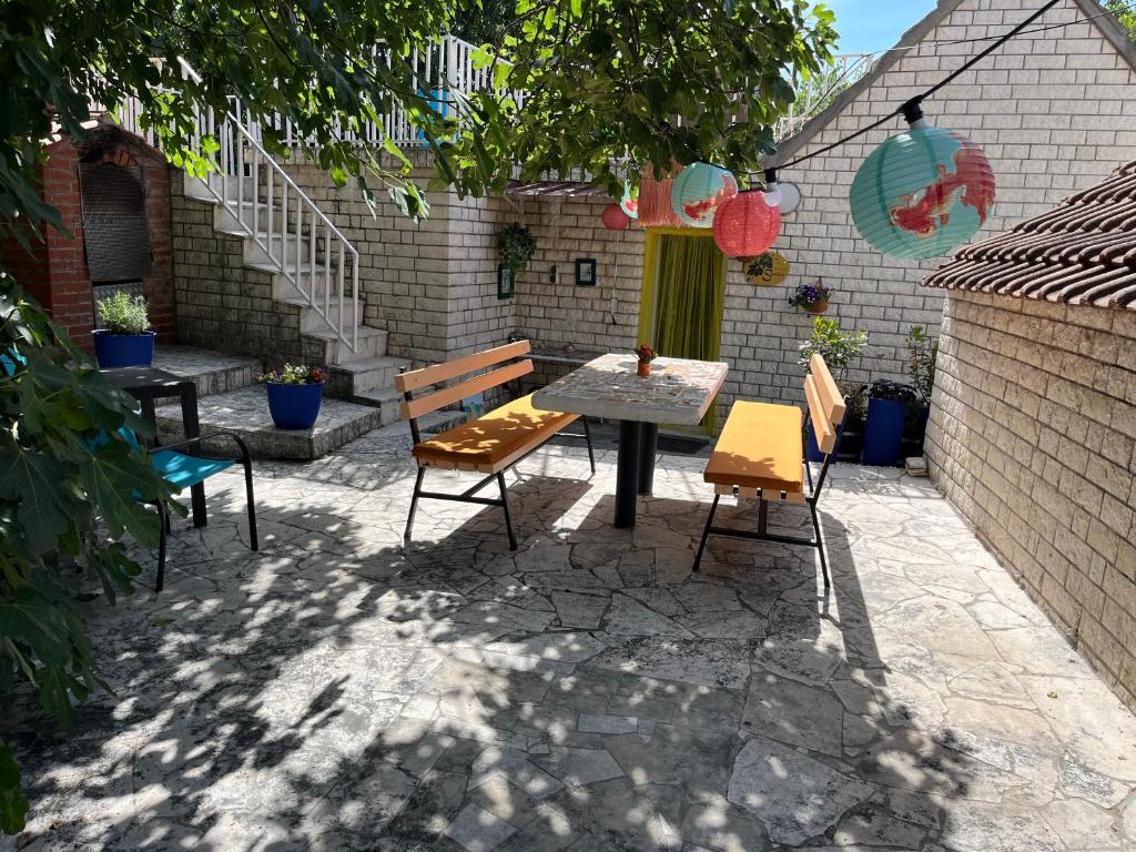 une terrasse avec une table, des chaises et un escalier. dans l'établissement Apartment Smokva, à Trogir