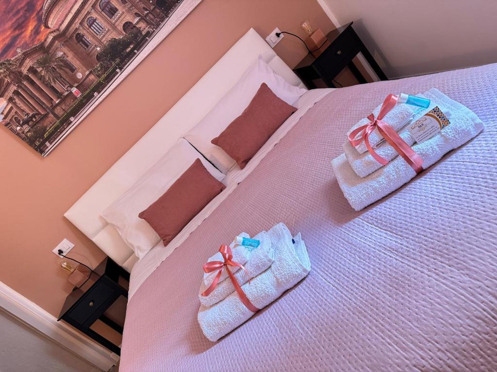 ein Bett mit zwei Babypantoffeln darüber in der Unterkunft B&B Palermo Pirri in Palermo