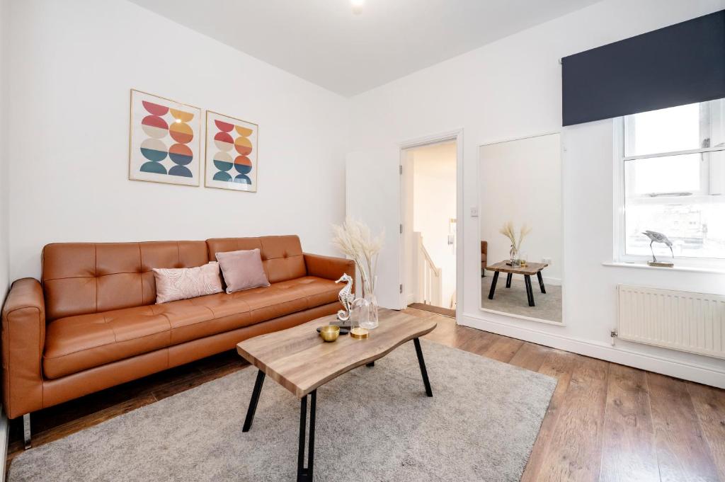 a living room with a brown couch and a table at Beautiful Flat Near the Center 11 min by tube in London