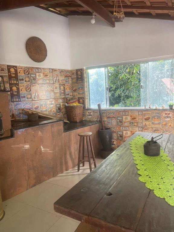 eine Küche mit einem Holztisch und einer Theke in der Unterkunft Pousada Villa Del Bosque - Chalé Familiare in Camanducaia