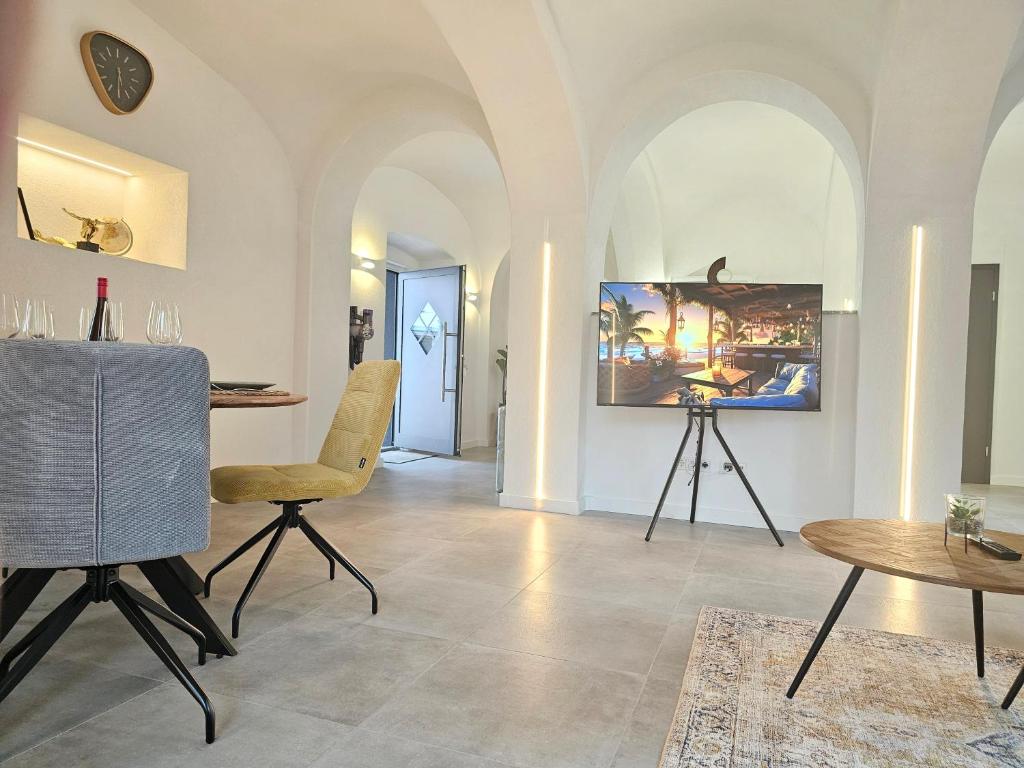 基彭海姆Design I Gewölbe I sanierter Pferdestall I EuropaPark I Boxspring I Nespresso I Terrasse I Parkplatz的客厅配有桌椅和摄像头