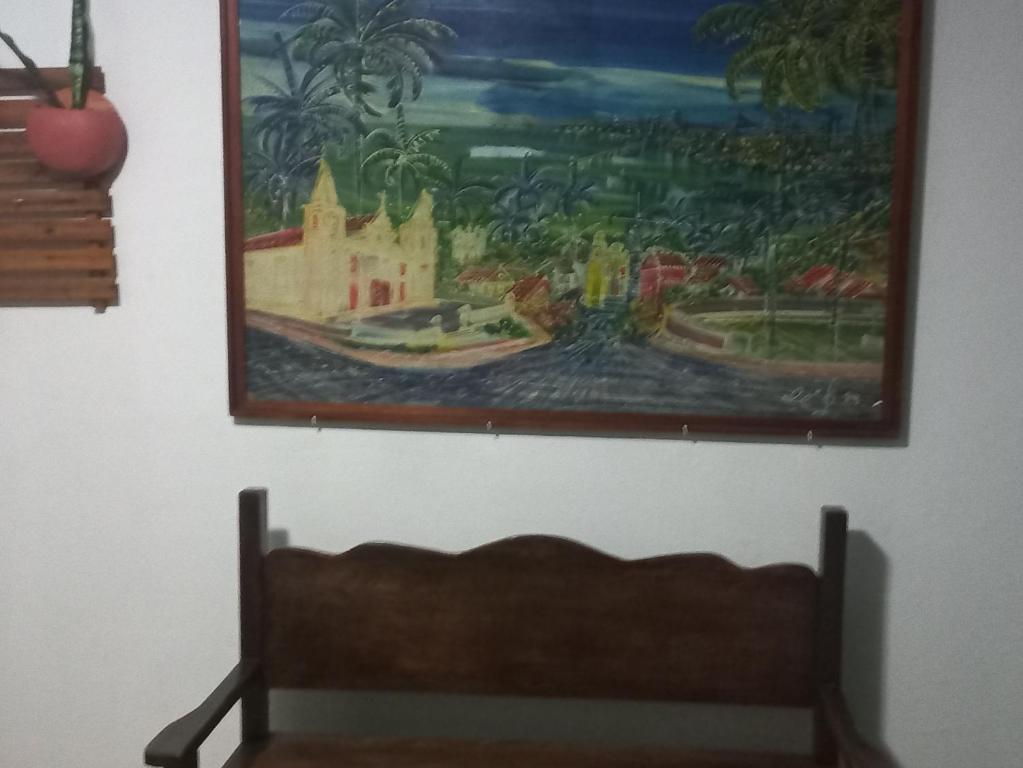 a painting hanging on a wall above a bench at Apartamento Praia do Janga Paulista Pe in Paulista