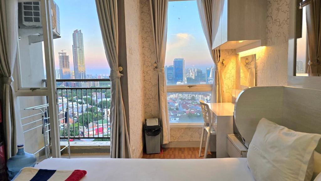 ein Hotelzimmer mit einem Bett und einem großen Fenster in der Unterkunft Studio Apartment JiExpo Kemayoran Sunrise View -Min Stay 3 nights- in Jakarta