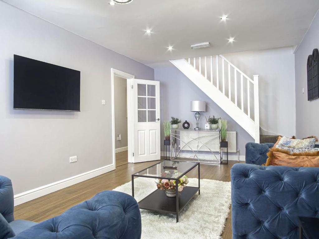sala de estar con sofá azul y TV en Luxe 5 Bed Bungalow In Snodland, Medway, Kent en Kent