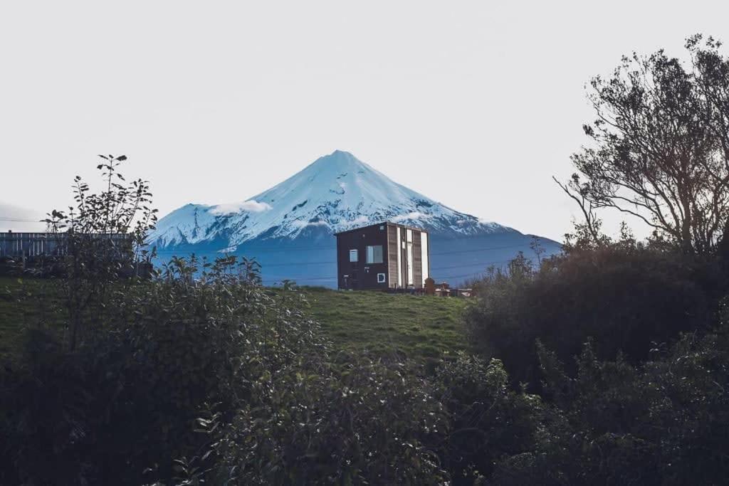 ein Berg in der Ferne mit einem Haus davor in der Unterkunft Taranaki Creekside KEA in Stratford