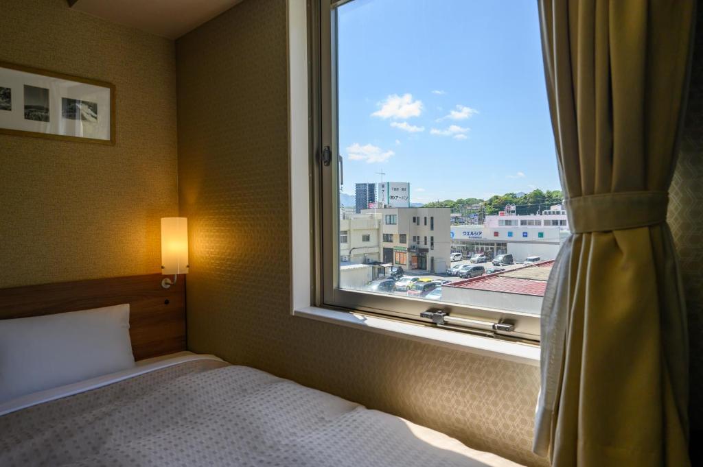 Postel nebo postele na pokoji v ubytování Hotel Econo Kameyama