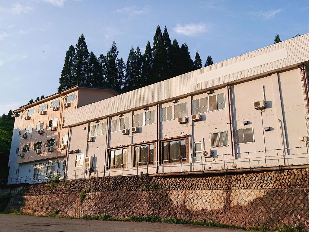 een gebouw op een heuvel met bomen op de achtergrond bij Hachikita U Base in Kami