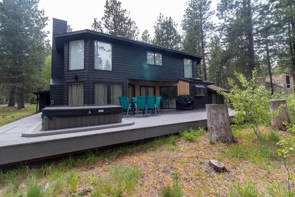 ein schwarzes Haus mit einer Terrasse im Wald in der Unterkunft Jacobs Ladder - Black Butte Ranch in Sisters