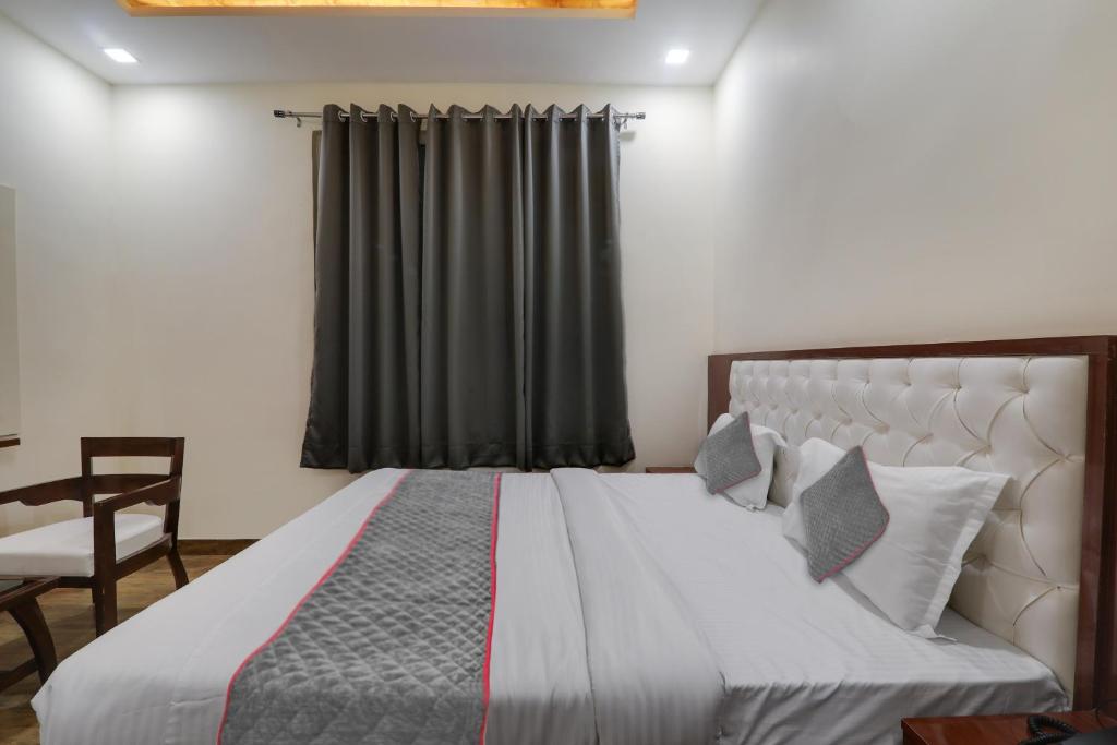 a bedroom with a large bed with a black curtain at Townhouse Hotel Trijal Inn in Lucknow
