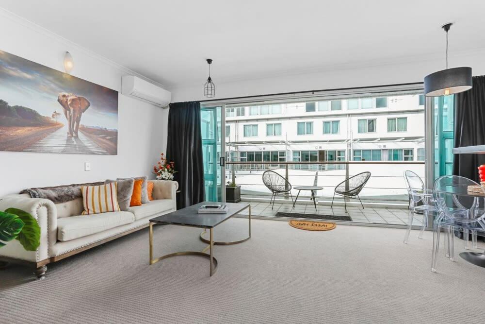 a living room with a couch and a table at Funky One Bedroom Apartment on Princes Wharf in Auckland