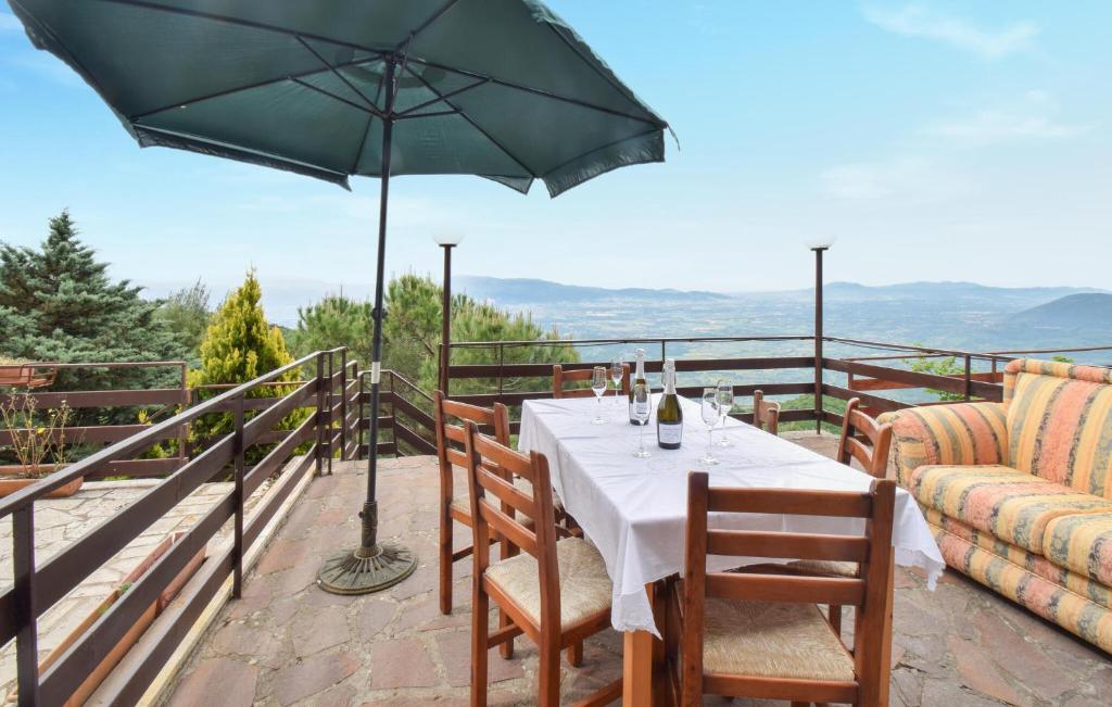 a dining table with an umbrella on a balcony at 2 Bedroom Lovely Home In Serrone in Serrone