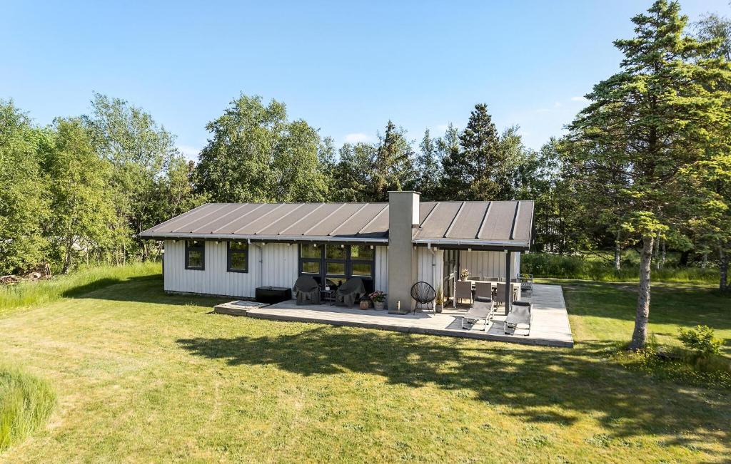 a small white house with a patio in a yard at Gorgeous Home In Strandby With Kitchen in Strandby