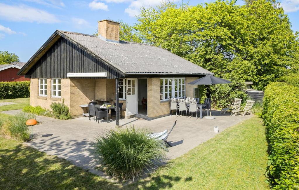a small house with a patio and a table and chairs at 3 Bedroom Awesome Home In Brenderup Fyn in Skovs-Højrup