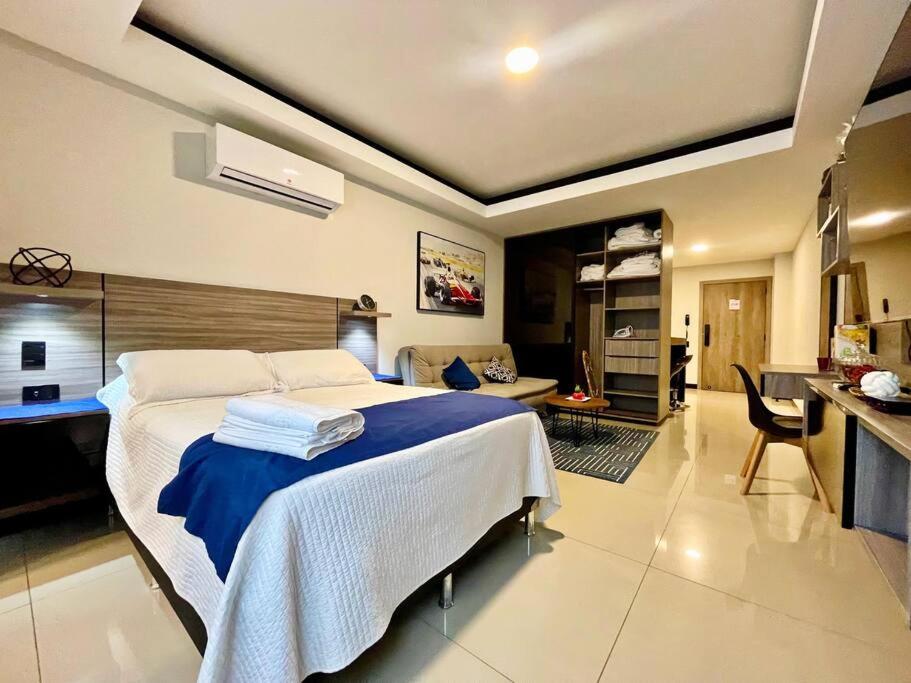 a bedroom with a large bed and a kitchen at Sky Elite Depto de lujo in Santa Cruz de la Sierra