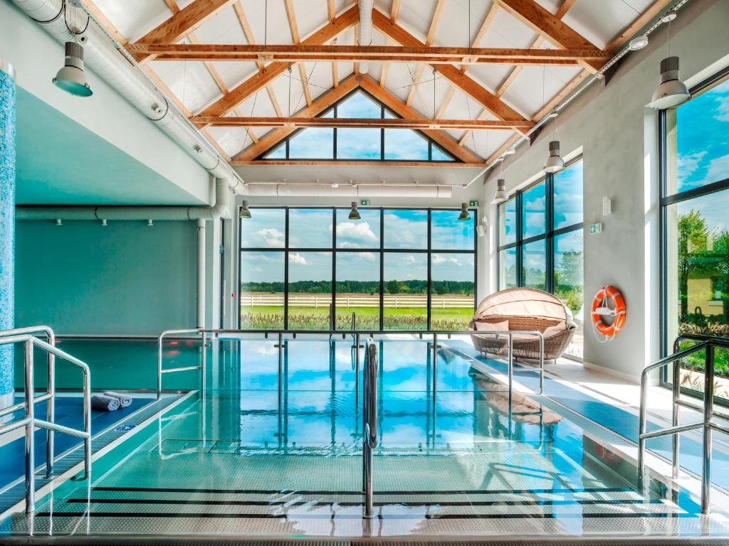a swimming pool in a house with a glass ceiling at Sielanka Nad Pilicą in Warka