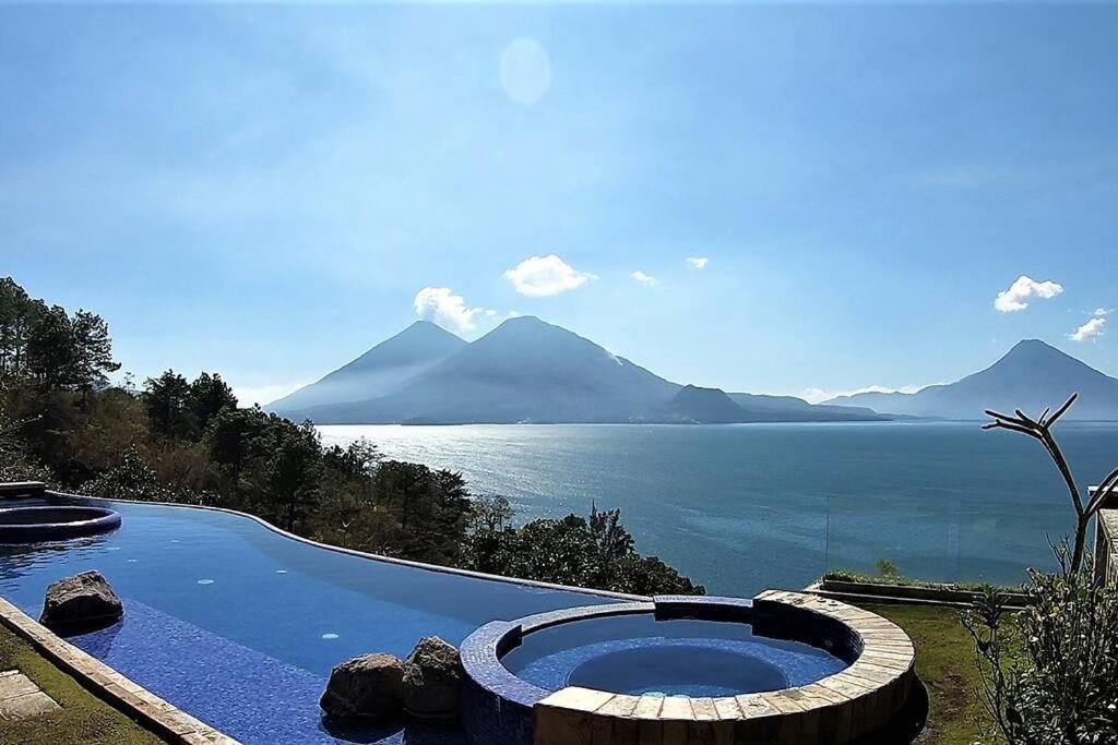 una piscina con vistas al agua y a las montañas en Exclusive Home Atitlan AT020, en Santa Catarina Palopó