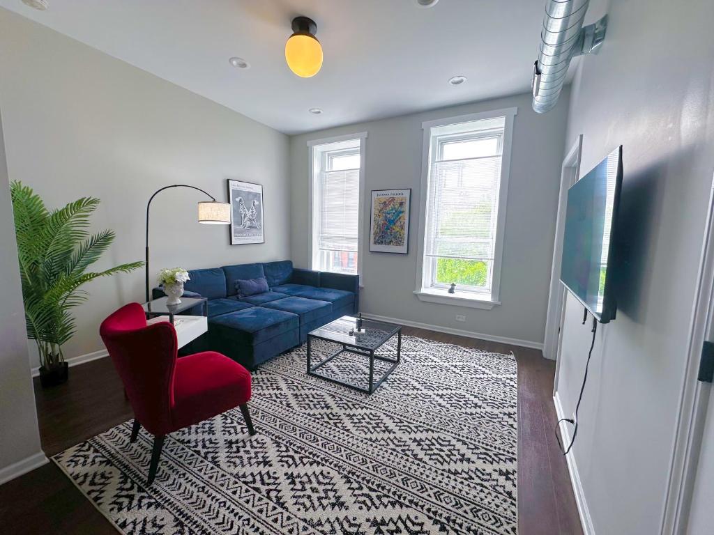uma sala de estar com um sofá azul e uma cadeira vermelha em The Secret West Loop Oasis with in-unit washer and dryer for up to 6 guests em Chicago