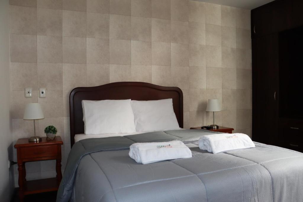 ein Schlafzimmer mit einem Bett mit zwei Handtüchern darauf in der Unterkunft Hotel Sierra Alta Colca in Chivay