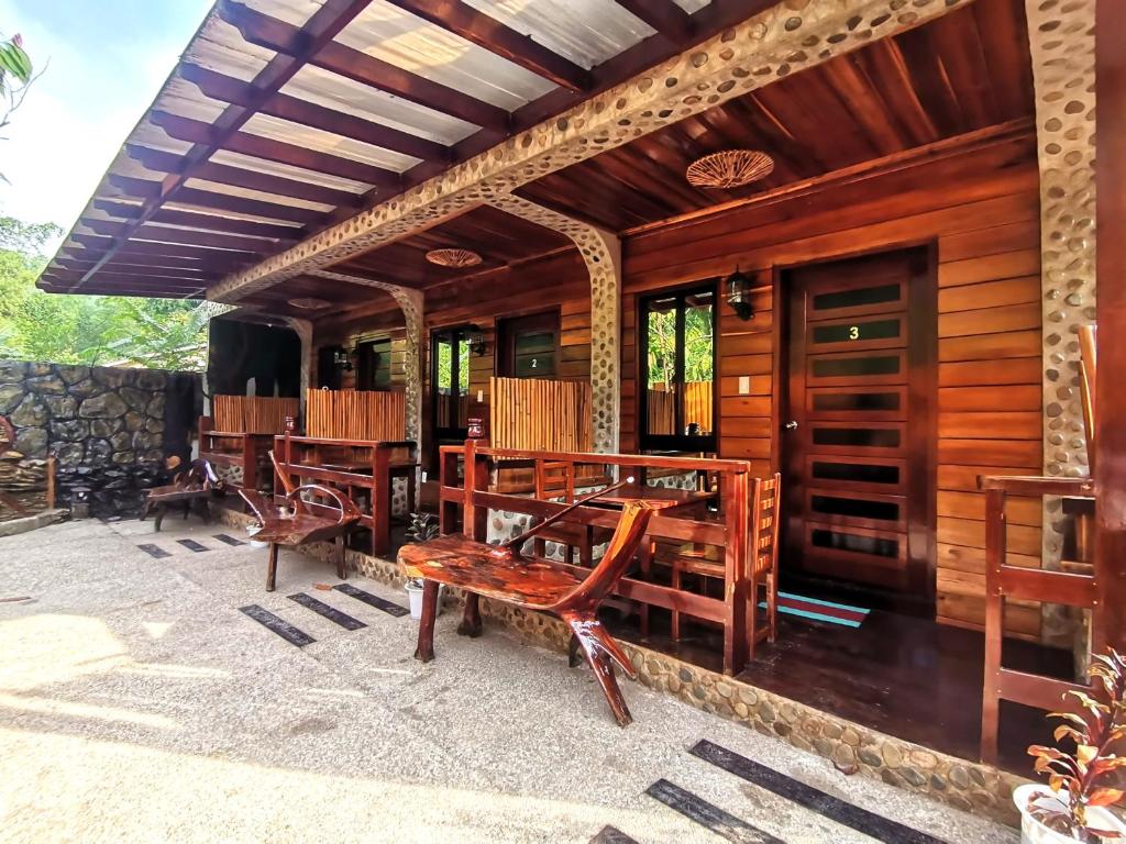 un patio con tavoli e sedie in legno su una casa di Forest wood-Port Barton a San Vicente