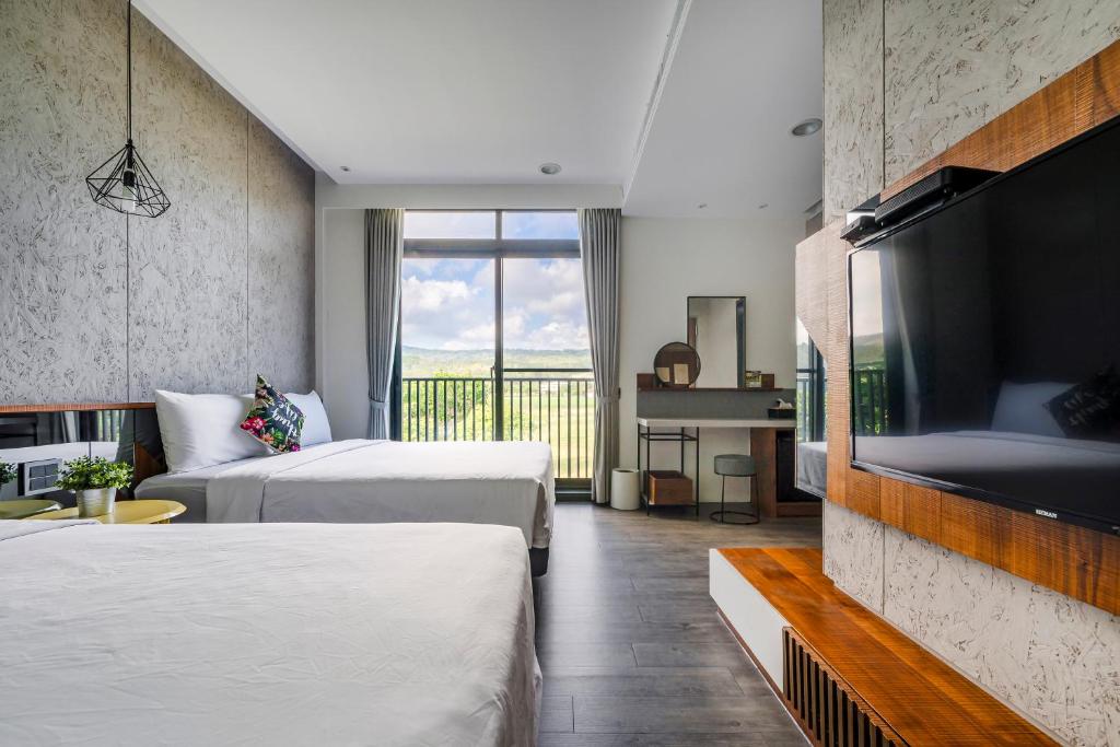 a hotel room with two beds and a flat screen tv at MH48 Hotel in Kenting