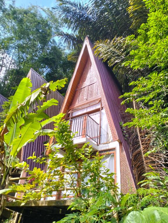 a small pink house with a window and trees at Alpha 3 Eco Cabin in Rantepao