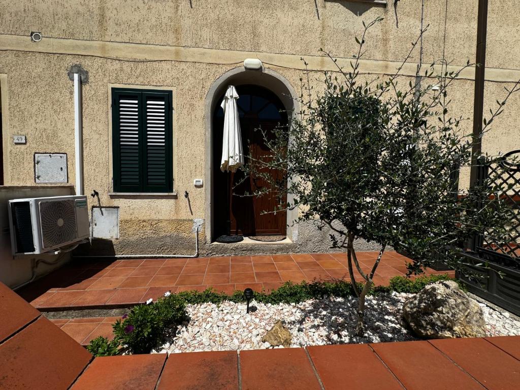 ein Gebäude mit einem Regenschirm vor einer Tür in der Unterkunft La Vecchia Chiassaia (mare/montagna) in La Pescaia