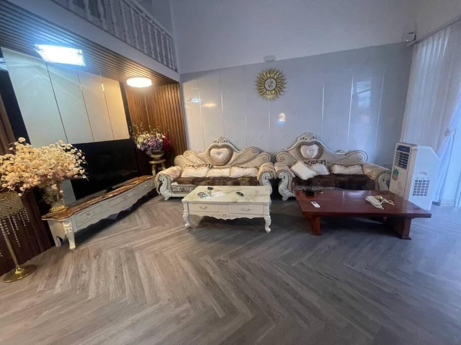 a living room with couches and tables in a room at Citadel Villa- Kinh Đô Huế in Hương Trà