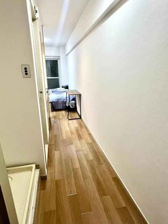 un pasillo con una habitación con 2 camas y suelo de madera en Shinjuku West Central Park House, en Tokio