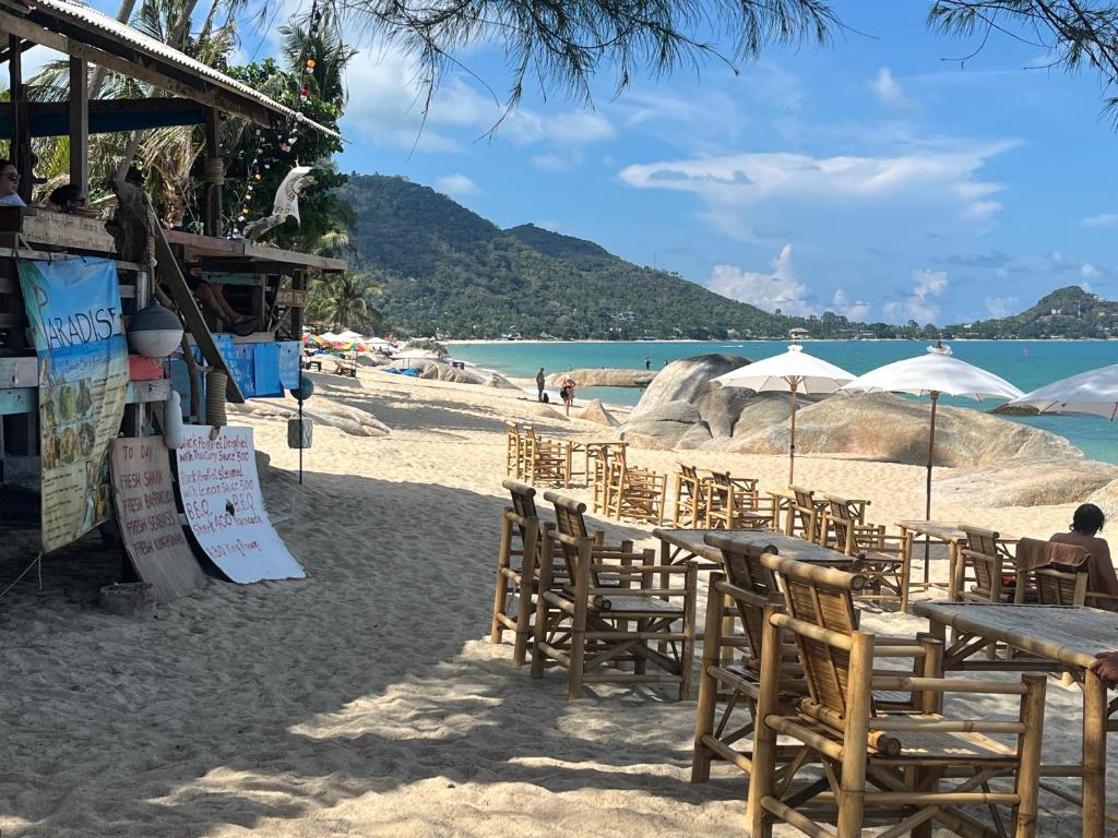 un grupo de mesas y sillas en una playa en Paradise Bungalows Lamai Beach, en Koh Samui 