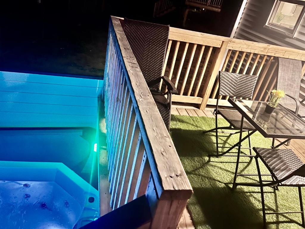 a deck with a pool and a table and a chair at Modern Vac Home, private Hot tub, close to airport in Dieppe