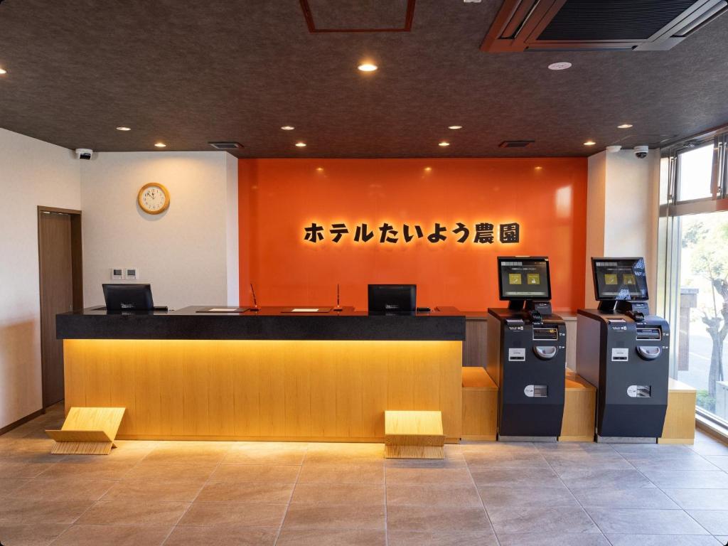 Hotel Taiyo Noen Tokushima Kenchomae في توكوشيما: غرفة انتظار مع كونتر ومكينين